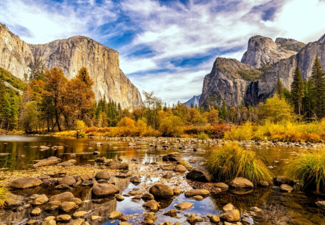 Yosemite Valley in herfst met El Capitan, gouden bomen en Merced River met rotsen in voorgrond