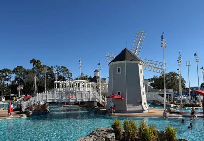 Disney resort zwembadcomplex met decoratieve windmolen en witte bruggen bij helder weer
