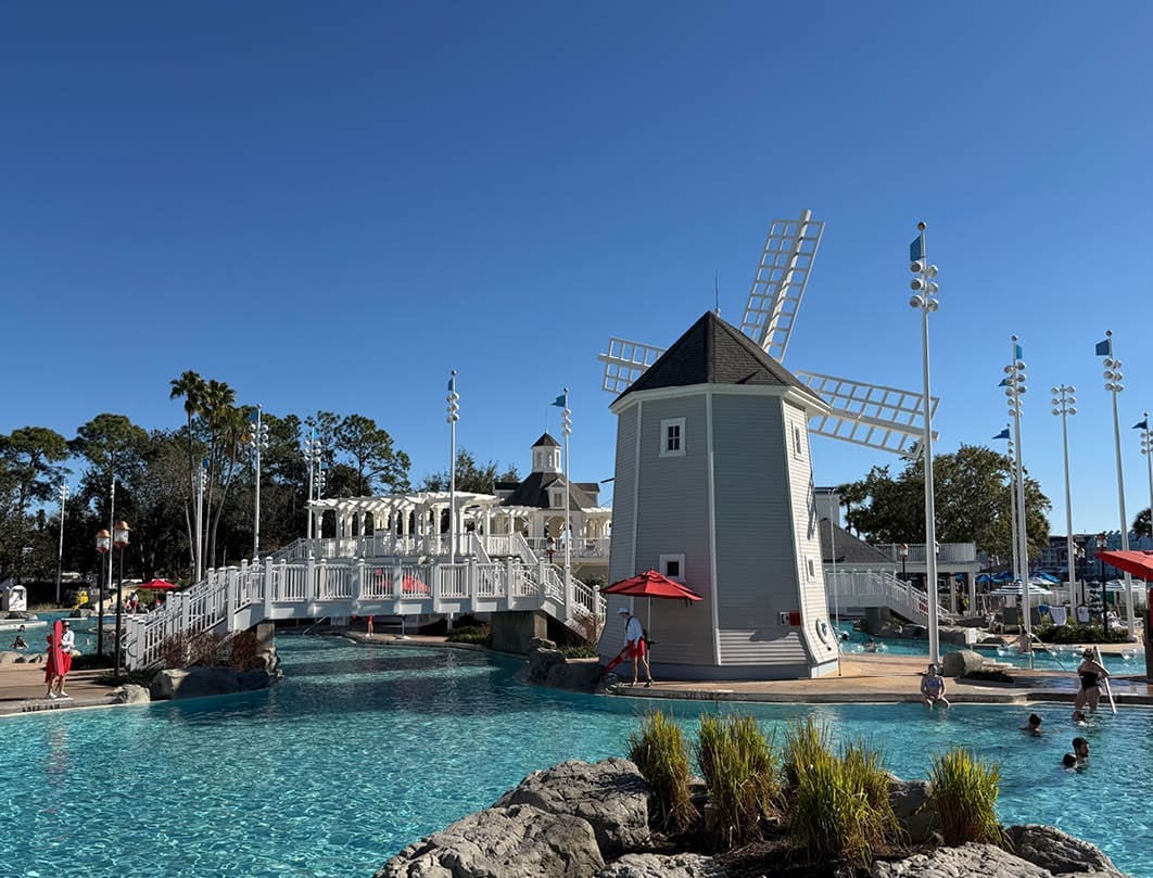 Disney resort zwembadcomplex met decoratieve windmolen en witte bruggen bij helder weer