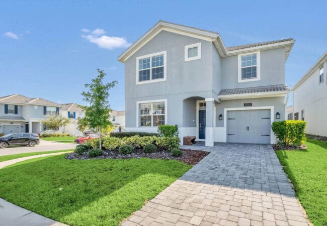 Moderne open keuken met zwarte kasten, wit kookeiland en aangrenzende eetkamer met grote ramen