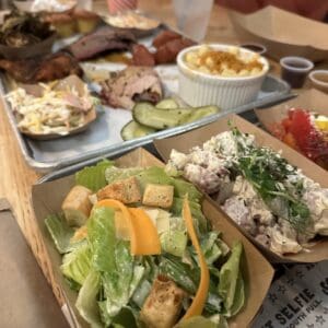 Uitgebreide Butcher Board met BBQ-vlees, mac & cheese, coleslaw en salades bij Polite Pig in Disney Springs
