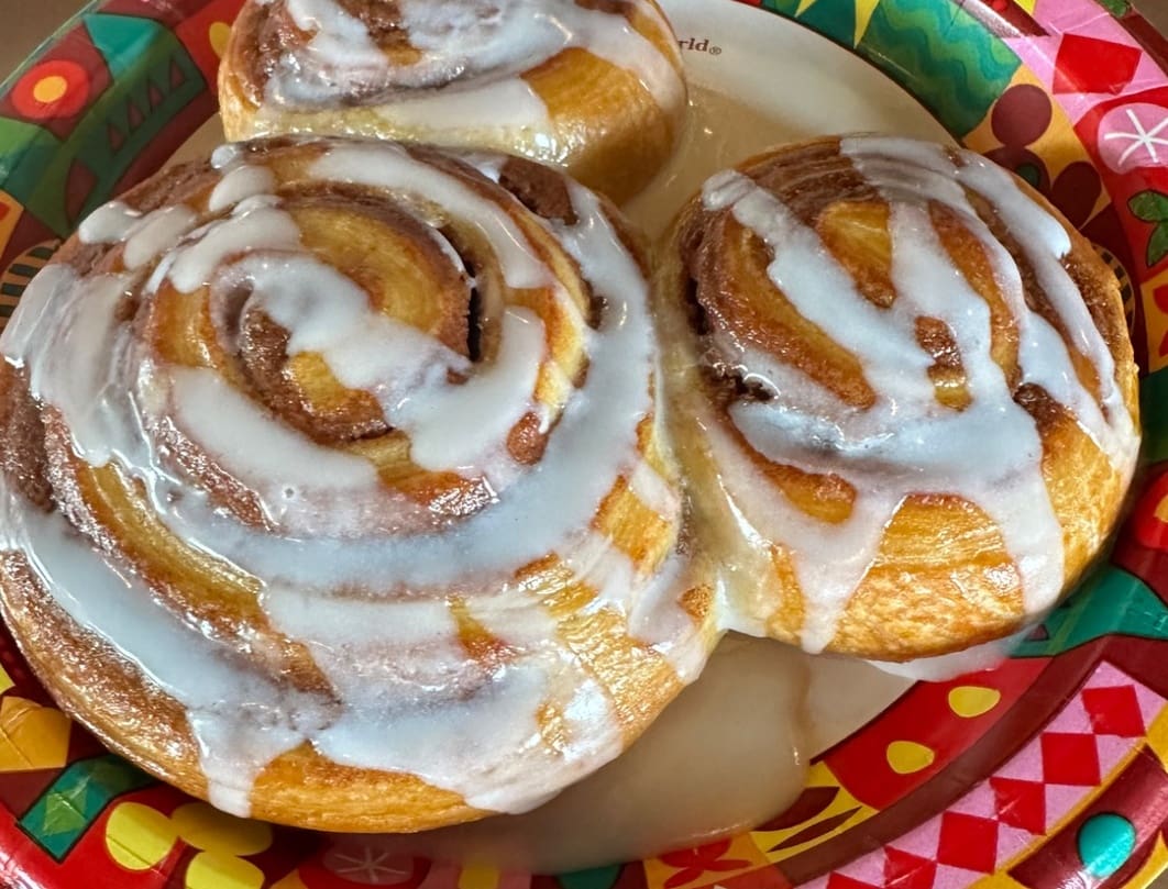 Mickey cinnamon roll met icing op een bord in een Disney park