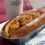 De Cheddartistique hotdog in Disney Adventure World Disneyland Paris — met cheddar, bacon en krokante uitjes in een briochebroodje